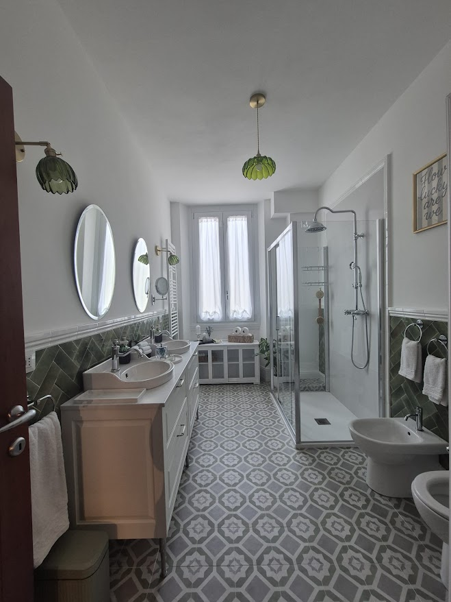 Bagno con doppio lavabo e piastrelle verdi